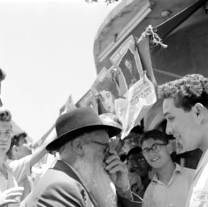 Joodse jongemannen en een oudere man staan voor een kiosk en voeren een gesprek , Bestanddeelnr 255-1846 photo