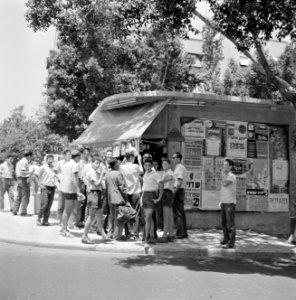 Joodse jongemannen met keppeltjes op staan bij een kiosk waar kranten worden ver, Bestanddeelnr 255-1845