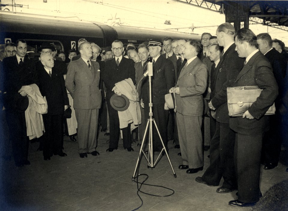 HUA-170434-Afbeelding van de onvangst van president-directeur dr. ir. F.Q. den Hollander en directeur drs. D.J. Wansink van de N.S. (3e en 4e van links) op het perron van het N.S.-station Roosendaal te Roosendaa
