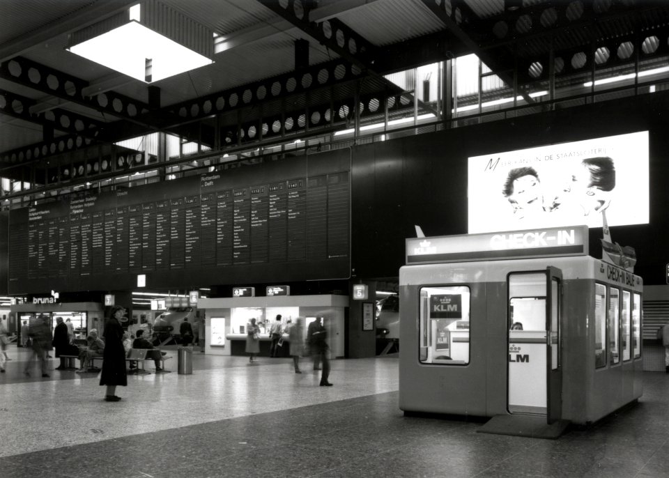 HUA-170509-Interieur van het N.S.-station Den Haag C.S. te Den Haag- hal, met rechts de incheckbalie van de K.L.M. voor luchtreizigers (Schiphol)
