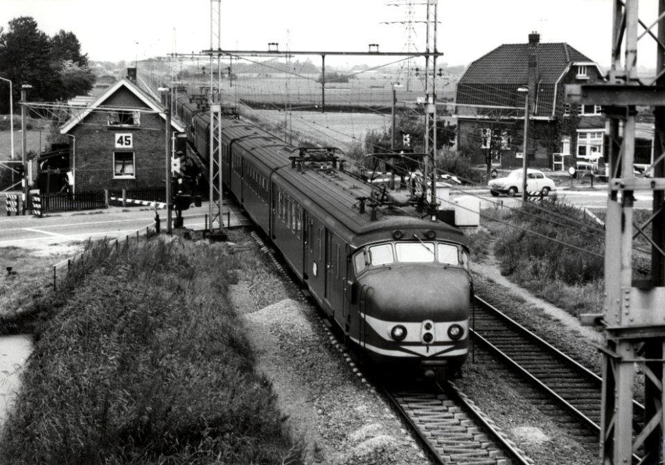 HUA-170530-Afbeelding van een trein bestaande uit electrische treinstellen mat 1954 van de NS voorop nr 769 plan P bij de spoorwegovergang in de Rijksstraatweg t