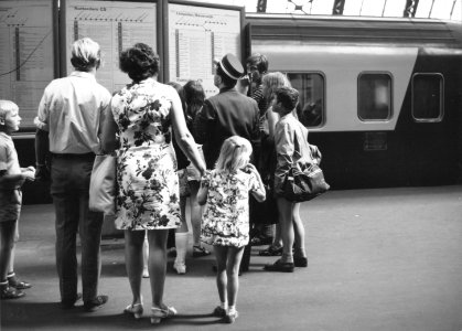 HUA-171278-Afbeelding van treinreizigers bij de vertrektijdenborden op een perron van het NS station Amsterdam CS te Amsterdam Op de achtergrond een TEE