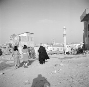 Jaffa. Wandelaars, onder wie een christelijke geestelijke, op straat met op de …, Bestanddeelnr 255-0076 photo