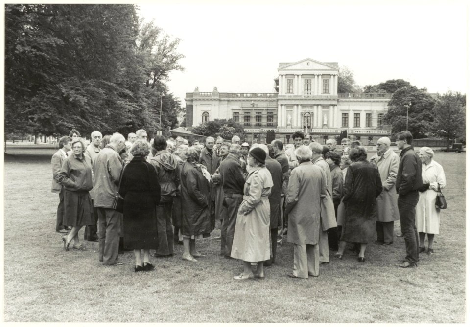 Groep geïnteresseerde Haarlemmers tijdens een rondleiding op het Vlooienveld. Op de achtergrond Paviljoen Welgelegen. NL-HlmNHA 540021215