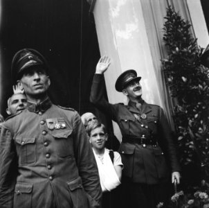 Links een KNIL-militair en rechts een Canadese officier die zwaait. Tussen hen , Bestanddeelnr 900-4996