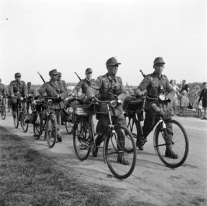 Lopend naast hun fietsen gaan zij hun wapens en uitrusting inleveren, Bestanddeelnr 900-2895