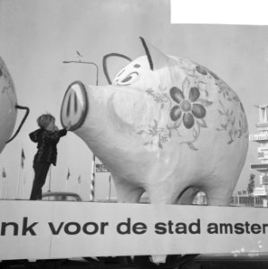 Kind dat een van de reuzegrote spaarvarkens van nabij bekijkt, Bestanddeelnr 918-3610