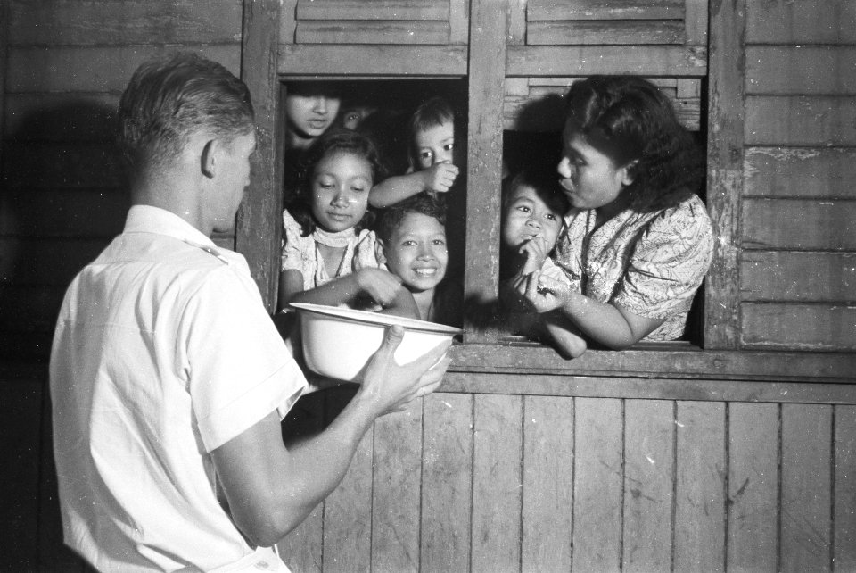 Kinderen in een wagon krijgen iets aangereikt vanuit een kom, Bestanddeelnr 514-6-5
