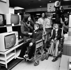 Kinderen in rolstoelen en begeleiders bekijken televisies, Bestanddeelnr 926-8397