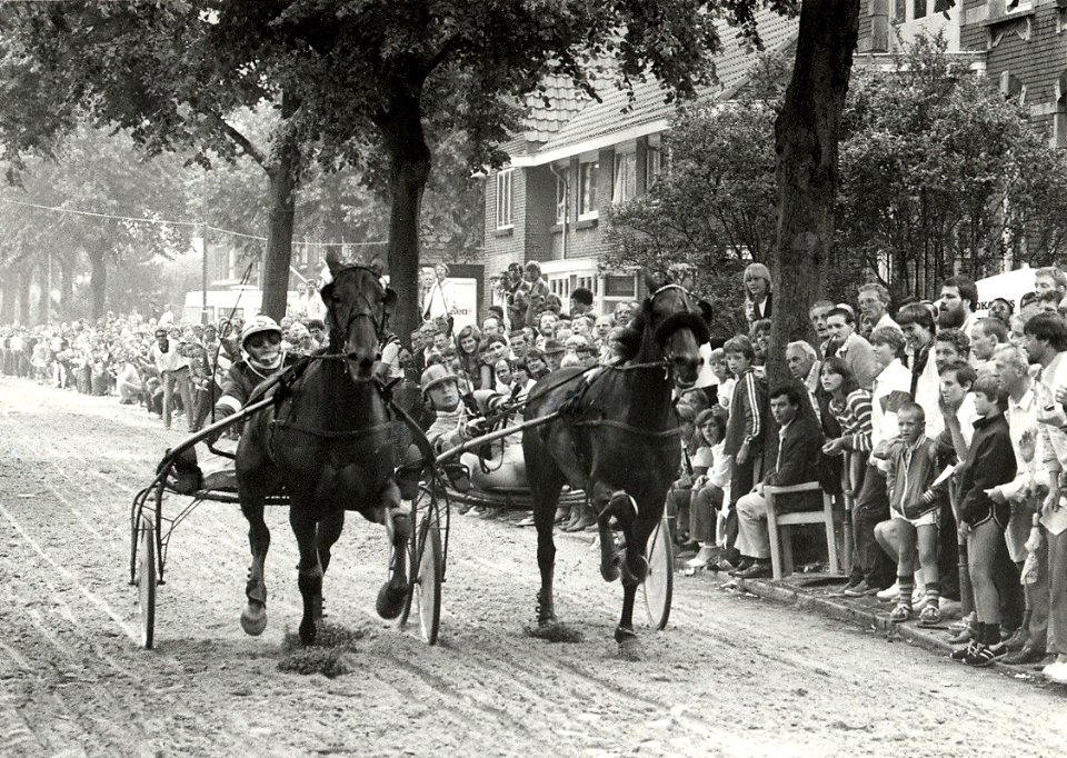 Kortebaandraverij in de Santpoortse Hoofdstraat tijdens de feestweek. Aangekocht in 1983 van fotograaf C. de Boer. - Negatiefnummer 22163 k 8 a. - Gepubliceerd in het Haarlems Dagblad van 06, NL-HlmNHA 1478 25900 K 38
