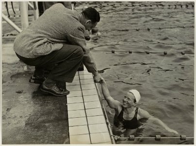Doelverdediger Piet Kraak feliciteert Irma Schuhmacher als overwinnaar van de 400 meter vrije slag. Stoop's Bad. NL-HlmNHA 54010692