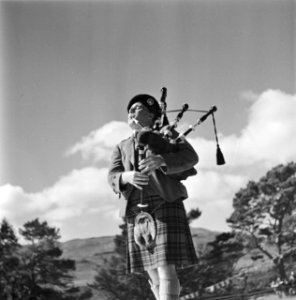 Doedelzakspeler blaast op zijn instrument tijdens de Highland Games, een negenti, Bestanddeelnr 254-2830