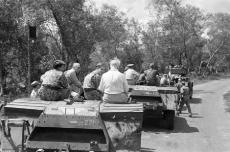 Dr. C.P.M. Romme (in licht overhemd). Zit op een pantserwagen, onderdeel van een, Bestanddeelnr 145-2-3