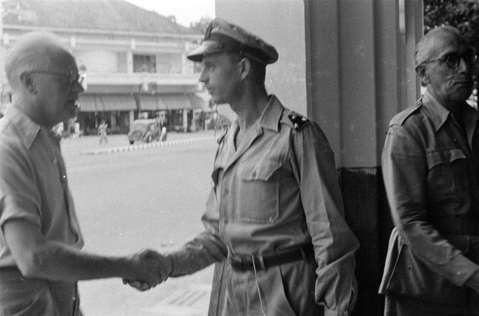 Dr. C.P.M. Romme in licht overhemd schudt de hand van een KNIL-officier (kapitei, Bestanddeelnr 139-6-1