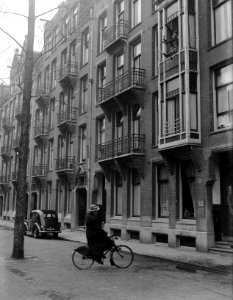 Dr. Max Euwe fietst door Amsterdam en wuift naar boven waar mensen uit het raam , Bestanddeelnr 902-5843