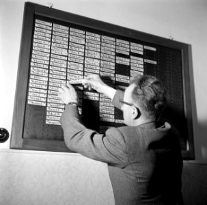 Directeur Hoppe bij het bord met de namen van alle aanwezigen in het schippersi…, Bestanddeelnr 254-1721