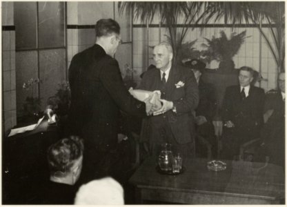 Directeur A. van Driel van de Gemeente Reiniging neemt afscheid en ontvangt een cadeau van zijn opvolger, de heer Remme(links). NL-HlmNHA 54004788
