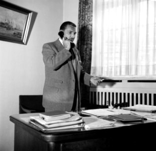 Directeur H. van Gunsteren telefonerend achter zijn bureau in het kantoor in Du…, Bestanddeelnr 254-1015