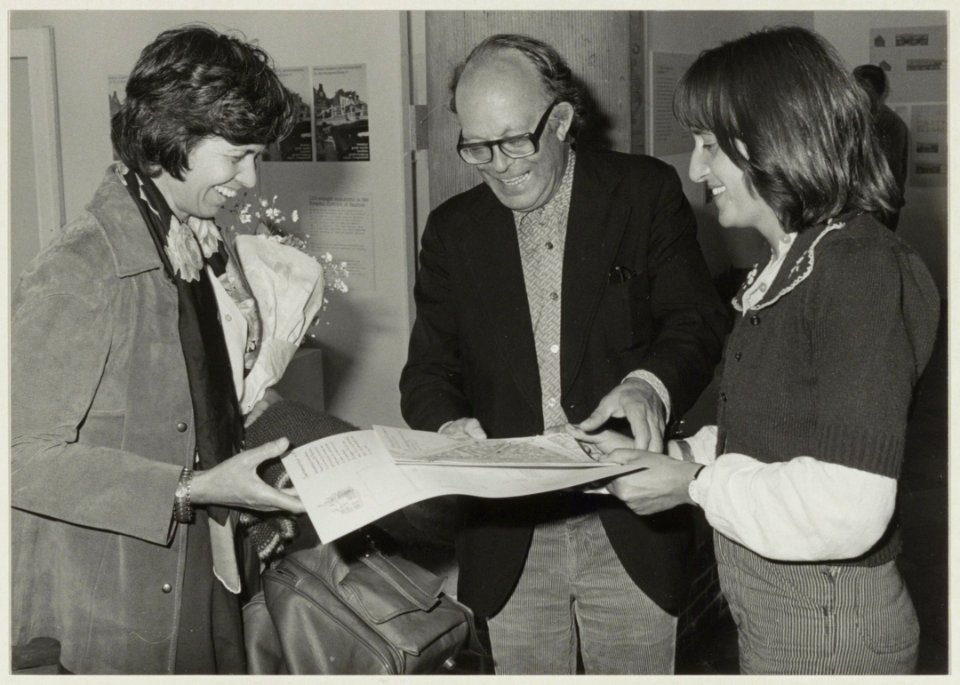 Directeur Dick Couvee verwelkomt de 10.000ste bezoeker, mevrouw Tadema, van de tentoonstelling De Burgwalbuurt in de Vleeshal. Rechts Clara Brinkgreve. NL-HlmNHA 54005697