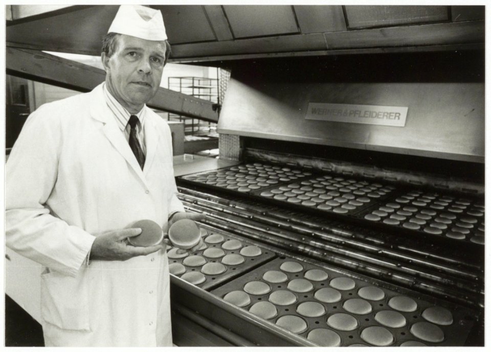 Directeur Hennie Budding van Bakkerij Vermaat BV bij platen met hamburgerbroodjes. NL-HlmNHA 54035079