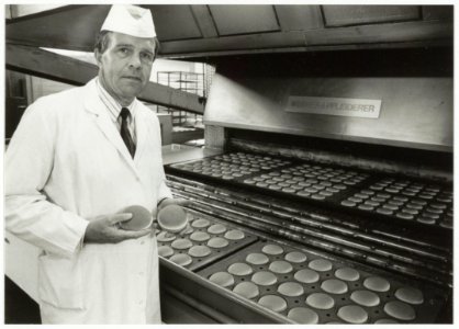 Directeur Hennie Budding van Bakkerij Vermaat BV bij platen met hamburgerbroodjes. NL-HlmNHA 54035079