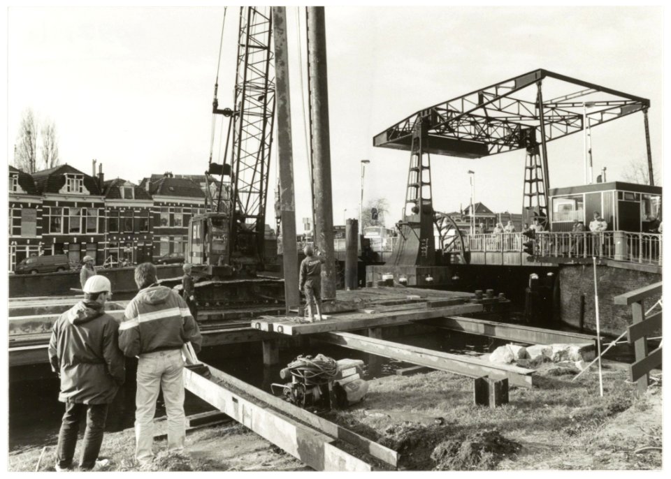 De eerste paal voor de nieuwe Langebrug gaat de grond in vanaf een in het Spaarne aangemeerde ponton. NL-HlmNHA 54035166