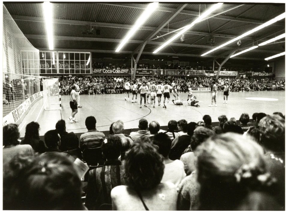 De handbalwedstrijd Nederland-Italië was goed voor ruim 1300 toeschouwers. Nederland was na de winst op Italië (18-17) de verrassende koloper. NL-HlmNHA 54035279