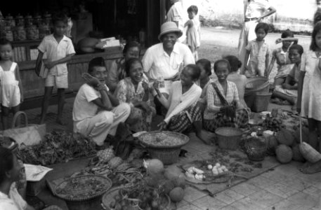 Djokjakarta. Kolonel Julian poseert met marktvrouwen, een van hen houdt een bank, Bestanddeelnr 3979