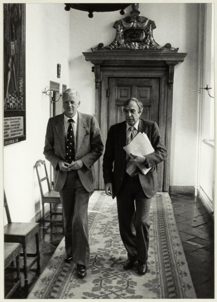 De zojuist afgetreden CDA-wethouders Piet Sikma ( Sociale Zaken) links, en Aad Vos ( Openbare Werken en economische zaken) rechts, in de gang van het stadhuis. NL-HlmNHA 54011515