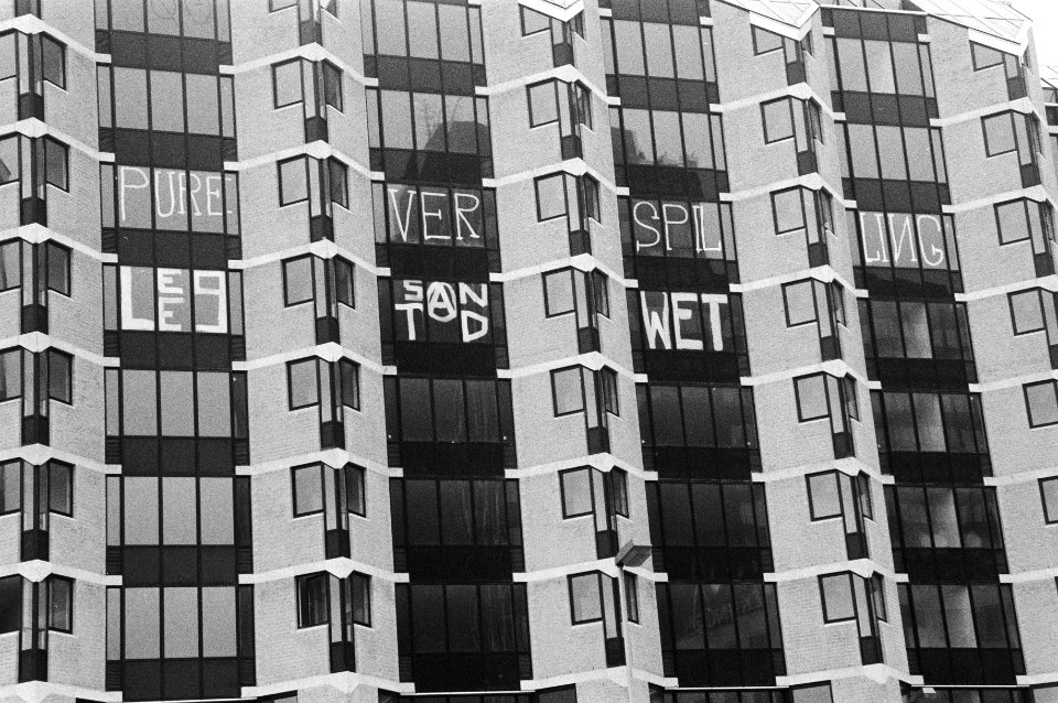 Gekraakte appartementen met tegen de ramen de tekst Peperdure verspilling leegs, Bestanddeelnr 931-2952