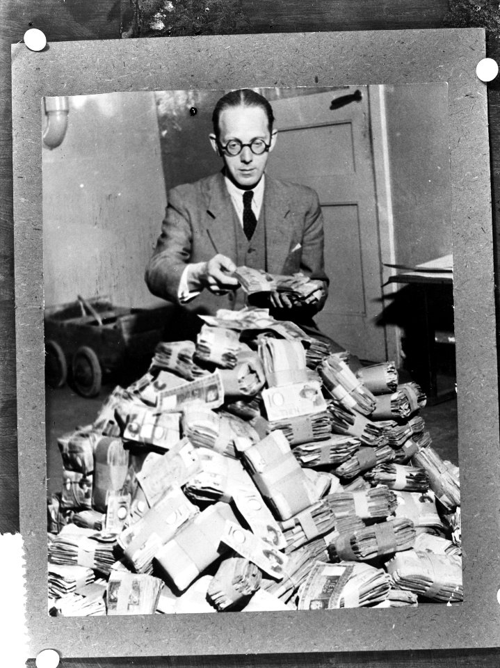 Geldzuivering Een man achter een grote stapel bankbiljetten, Bestanddeelnr 900-8314