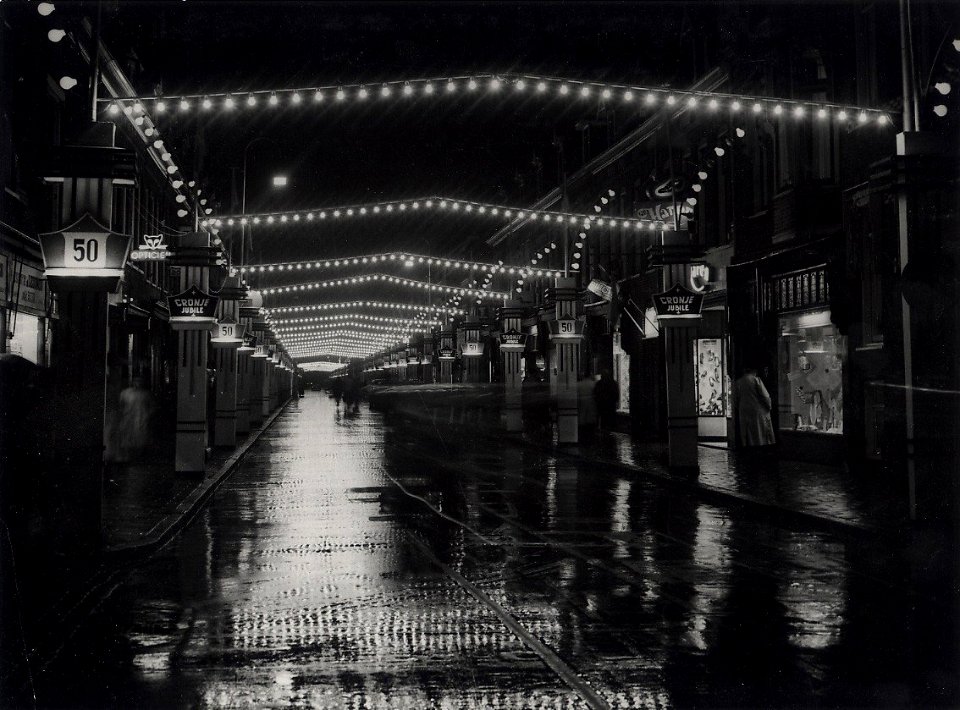 Generaal Cronjéstraat, feestelijk verlicht ter gelegenheid van het 50-jarig bestaan van de straat. Aangekocht in 1977 van fotograaf C. de Boer. Identificatienummer 54-004186, NL-HlmNHA 54004186
