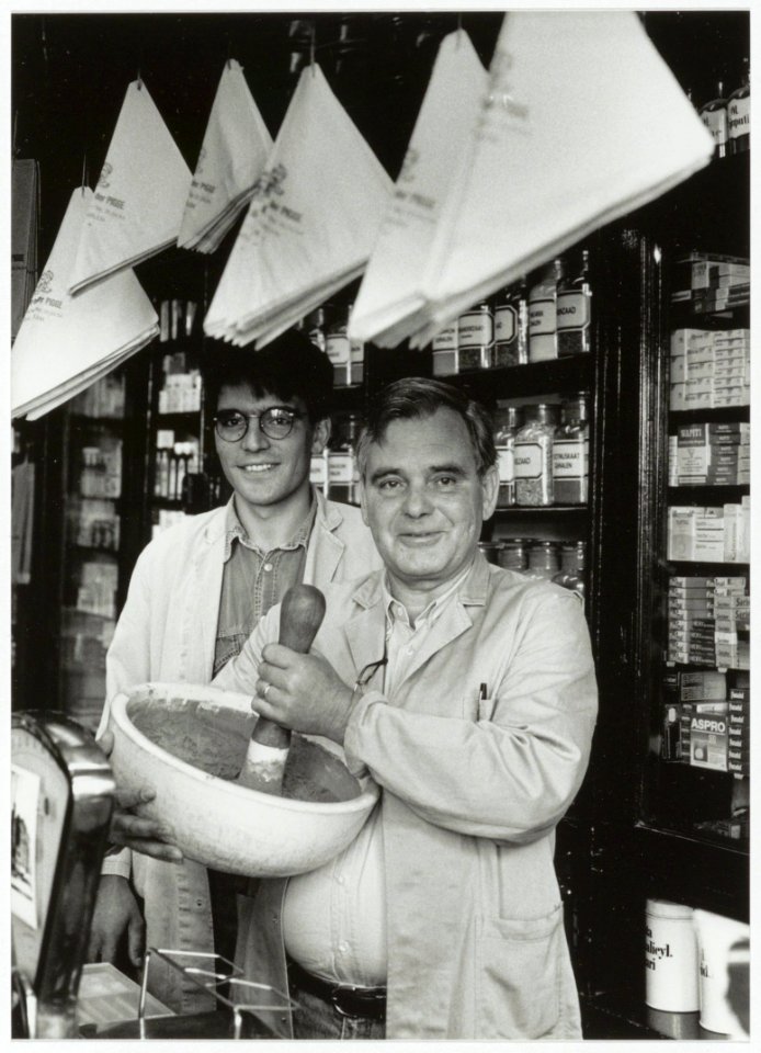 Drogisterij van der Pigge. Jan van Os met achter hem Menno van Os in de winkel aan de Gierstraat. NL-HlmNHA 54035313