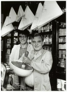 Drogisterij van der Pigge. Jan van Os met achter hem Menno van Os in de winkel aan de Gierstraat. NL-HlmNHA 54035313