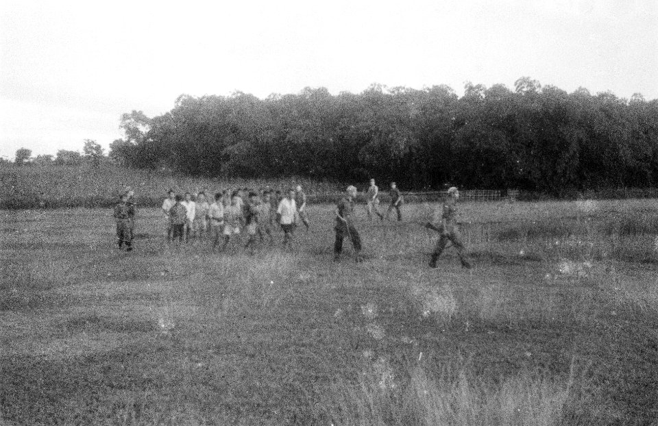 Een groep krijgsgevangenen wordt uit een veld afgevoerd, Bestanddeelnr 6741