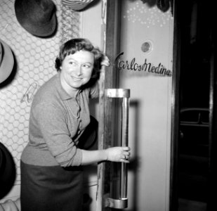 Een vrouw bij de deur van modehuis Carlos Medina, Bestanddeelnr 254-0216