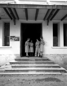 Enkele leden van het Vrouwenkorps KNIL staan in de deuropening van hun hoofdkwar, Bestanddeelnr 10658