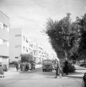 Een straat met flatgebouwen in Tel Aviv en wachtenden bij een bushalte en vracht, Bestanddeelnr 255-1293