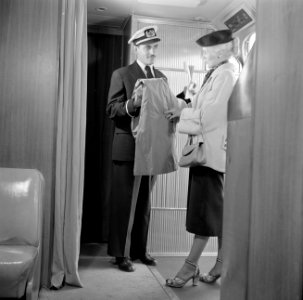Een steward en een vrouwelijke passagier bij de deur van een KLM-vliegtuig, Bestanddeelnr 254-5449