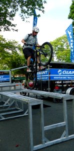 Mountain bike stunt cyclist Chris Clark does a wheelie on ramps