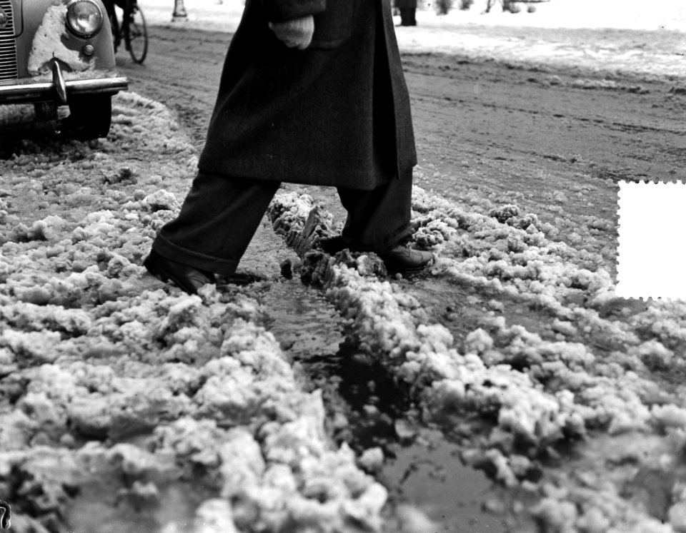 Moddergenoegens. Man stapt door moddersneeuw, Bestanddeelnr 904-9553