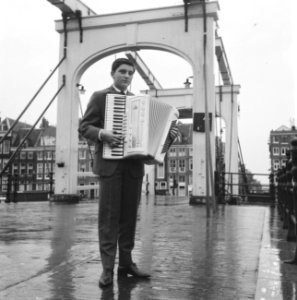 Maurice Nuisker, wereldkampioen accordeonspelen, voor de Magere Brug in Amsterda, Bestanddeelnr 913-0938