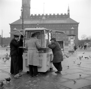 Mensen staan te eten bij een kiosk met op de achtergrond het raadhuis, Bestanddeelnr 252-8832 photo