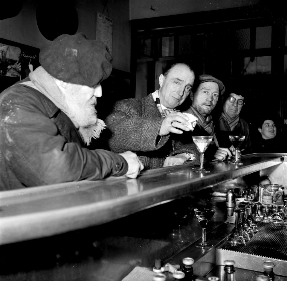 Mannen aan de bar van een café, terwijl een ervan melk in zijn glas giet, Bestanddeelnr 252-9500