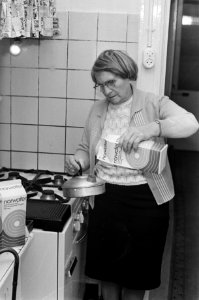 Mensen gebruiken Norwater, dame schenkt het water in ketel, Bestanddeelnr 925-1470