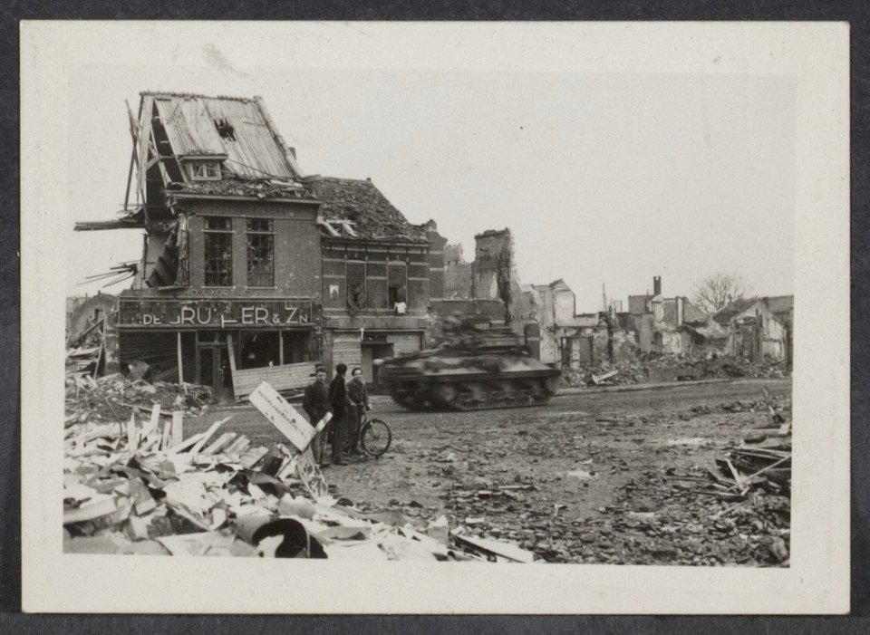 Oostburg (Zeeuws-Vlaanderen) Verwoest pand De Gruyter. Een tank raast voorbij.…, Bestanddeelnr 31003 026