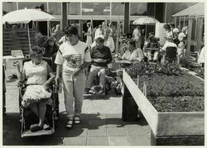 Na de opening maken bewoners van Nieuw Unicum een rondgang door de aangepaste tuin. NL-HlmNHA 54015599