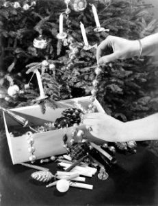 Vrouw haalt Kerstversiering uit een doos om een kerstboom op te tuigen, Bestanddeelnr 252-0950 photo