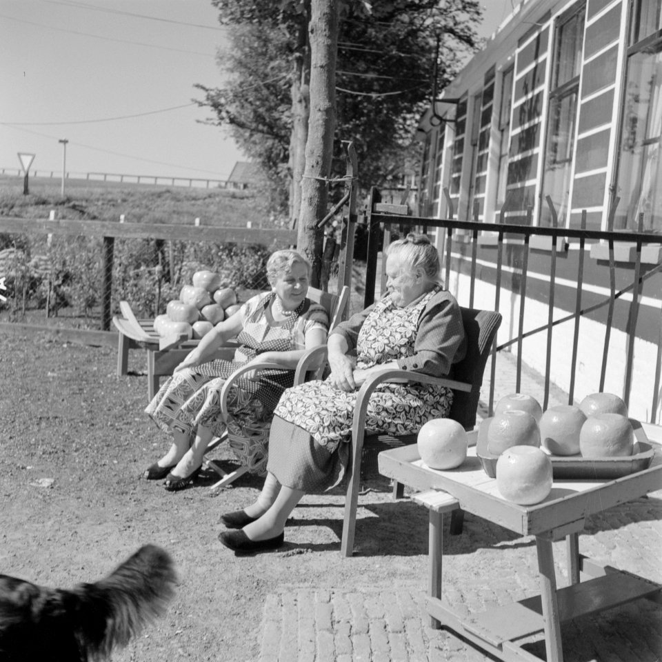 Vrouwen zitten in de zon te praten voor de Irene-Hoeve waar Edammer kaas wordt v, Bestanddeelnr 254-4001