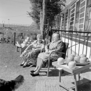 Vrouwen zitten in de zon te praten voor de Irene-Hoeve waar Edammer kaas wordt v, Bestanddeelnr 254-4001